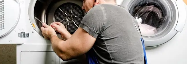 Dryer repair technician fixing a clothes dryer drum in Henderson, NV
