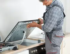 Appliance repair technician installing a built-in cooktop in Henderson, NV