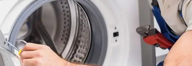 Appliance technician repairing a clothes dryer drum and internal parts in Henderson, NV