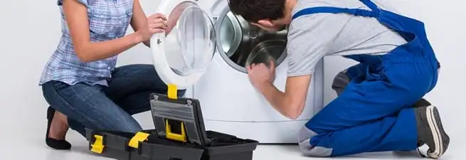 Washer repair technician inspecting a front-load washing machine with tools in Henderson, NV