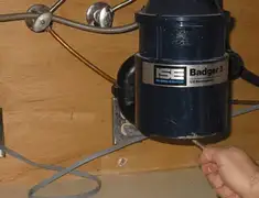 Garbage disposal repair technician tightening the mounting ring under a sink in Henderson, NV