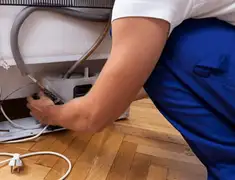 Appliance repair technician fixing refrigerator water line and connections in Henderson, NV