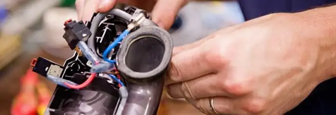 Vacuum repair technician reconnecting wiring and components in Henderson, NV