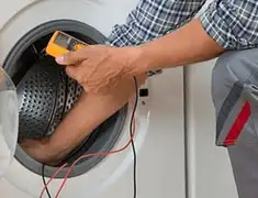Washing machine repair technician testing a front-load washer with diagnostic tools in Henderson, NV
