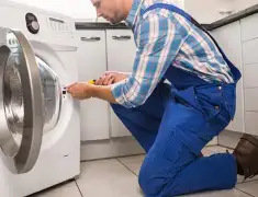 Washing machine repair technician servicing a front-load washer in Henderson, NV