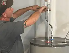 Water heater repair technician tightening supply line connections in Henderson, NV