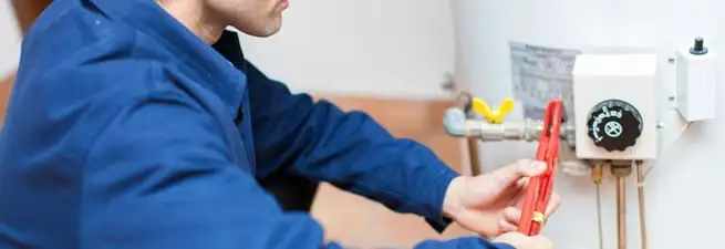 Water heater repair technician adjusting the temperature control and gas valve in Henderson, NV